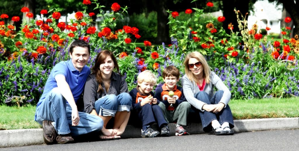 Family group sitting on the kerbside